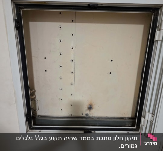 מסגרת חלון ממ"ד עם גומיות איטום וצירים במהלך עבודת תיקון